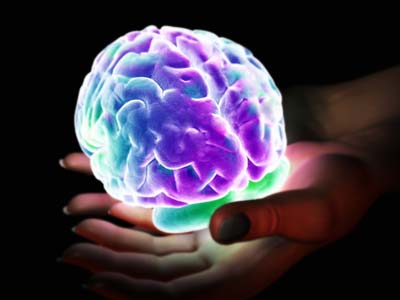 Glowing brain held by hands