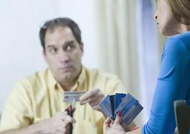 Man cutting credit cards, woman holding more credit cards.